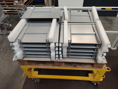 Welded, powder-coated sheet metal part constructions awaiting packaging